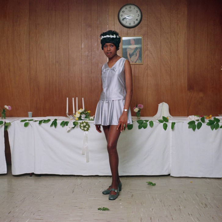woman in short dress standing in front of table
