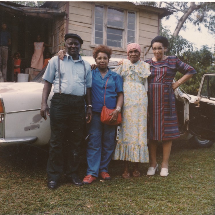 people posing in front of car